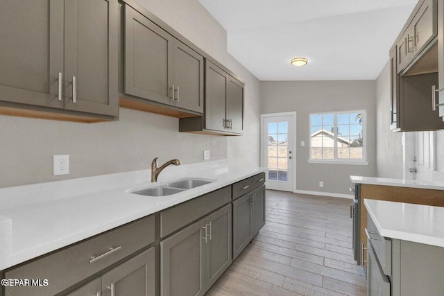 11860 Jim Ferriell Dr, El Paso, TX 79936 - kitchen with light countertops, gray cabinets, and light wood finished floors