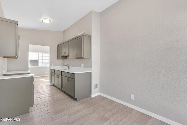 11860 Jim Ferriell Dr, El Paso, TX 79936 - kitchen with gray cabinetry, light wood finished floors, and light countertops