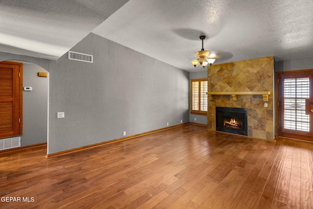 11852 Pete Rose Dr, El Paso, TX 79936 - unfurnished living room with a ceiling fan, a textured ceiling, a textured wall, arched walkways, and wood finished floors