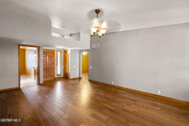 11852 Pete Rose Dr, El Paso, TX 79936 - empty room with a chandelier, wood finished floors, and arched walkways
