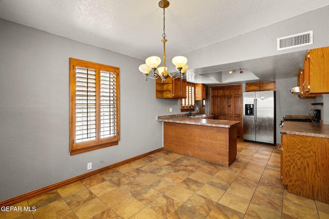 11852 Pete Rose Dr, El Paso, TX 79936 - kitchen featuring stainless steel refrigerator with ice dispenser, a peninsula, a textured ceiling, brown cabinets, and a chandelier