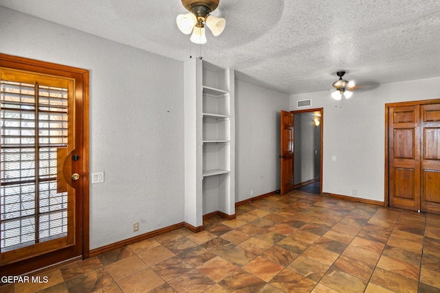 11852 Pete Rose Dr, El Paso, TX 79936 - unfurnished bedroom featuring a textured ceiling and stone finish flooring