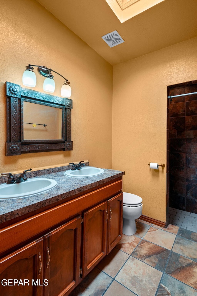 11852 Pete Rose Dr, El Paso, TX 79936 - full bath featuring double vanity, a tile shower, and a skylight