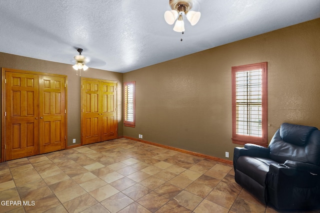11852 Pete Rose Dr, El Paso, TX 79936 - living area featuring a ceiling fan, plenty of natural light, a textured wall, and a textured ceiling