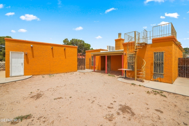 11852 Pete Rose Dr, El Paso, TX 79936 - exterior space with stucco siding, a chimney, and stairway