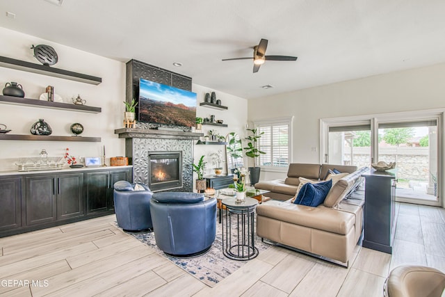 5705 Valley Lilac Ln, El Paso, TX 79932 - living room featuring ceiling fan, a tiled fireplace, and wood tiled floors
