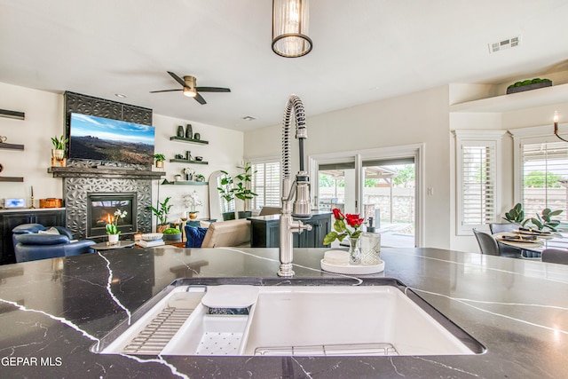 5705 Valley Lilac Ln, El Paso, TX 79932 - kitchen featuring stainless steel countertops, open floor plan, ceiling fan, and a fireplace