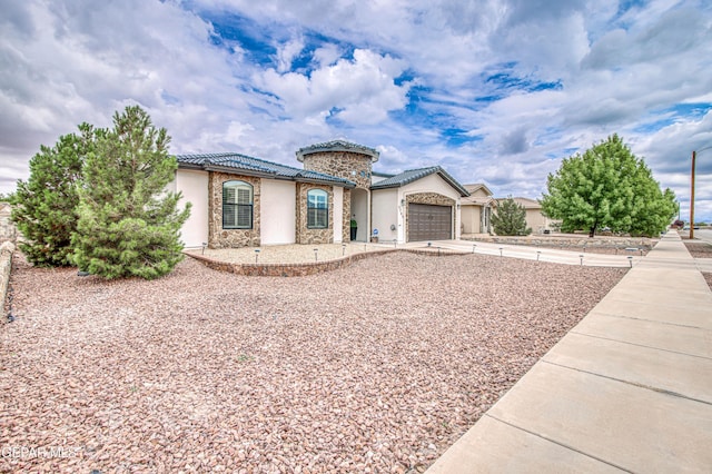 5705 Valley Lilac Ln, El Paso, TX 79932 - mediterranean / spanish house with stucco siding, a tiled roof, an attached garage, driveway, and stone siding
