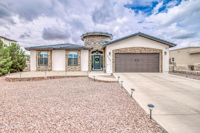 5705 Valley Lilac Ln, El Paso, TX 79932 - mediterranean / spanish-style house with driveway, a tiled roof, stone siding, an attached garage, and stucco siding