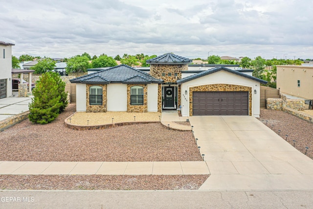 5705 Valley Lilac Ln, El Paso, TX 79932 - view of front of property with an attached garage, concrete driveway, stucco siding, a tile roof, and stone siding