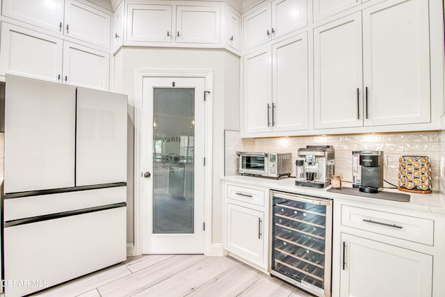 5705 Valley Lilac Ln, El Paso, TX 79932 - bar area featuring wine cooler, backsplash, freestanding refrigerator, and light wood-type flooring