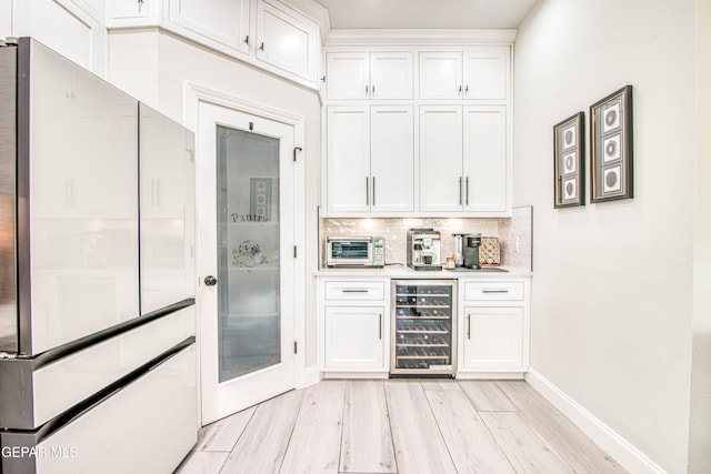 5705 Valley Lilac Ln, El Paso, TX 79932 - bar area with wine cooler, decorative backsplash, light wood-style flooring, and freestanding refrigerator