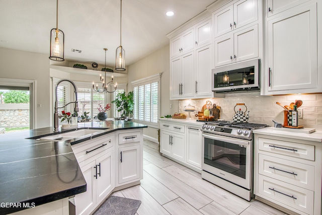 5705 Valley Lilac Ln, El Paso, TX 79932 - kitchen featuring appliances with stainless steel finishes, white cabinetry, tasteful backsplash, a chandelier, and recessed lighting