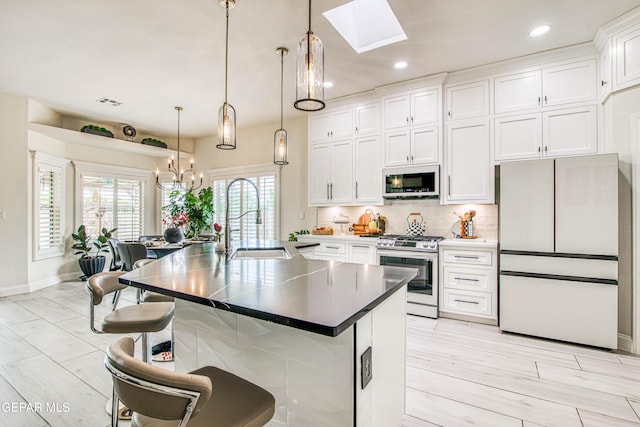 5705 Valley Lilac Ln, El Paso, TX 79932 - kitchen featuring white appliances, white cabinets, a skylight, backsplash, and recessed lighting