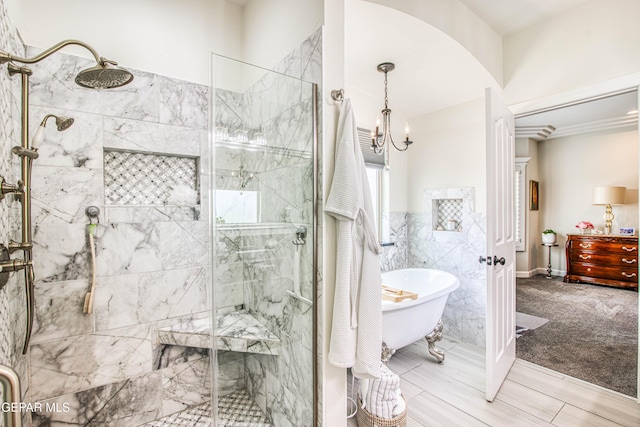 5705 Valley Lilac Ln, El Paso, TX 79932 - full bath featuring a stall shower, a freestanding bath, a chandelier, and tile walls