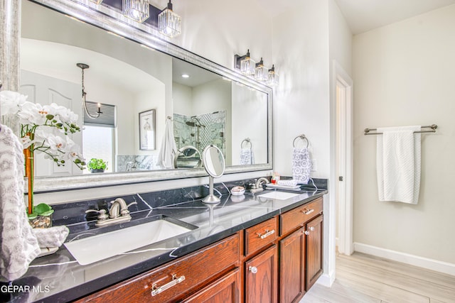 5705 Valley Lilac Ln, El Paso, TX 79932 - bathroom featuring double vanity, tiled shower, and wood finished floors