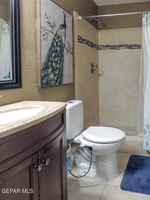 10945 Gary Player Dr, El Paso, TX 79935 - full bathroom featuring vanity, a stall shower, and tile patterned flooring