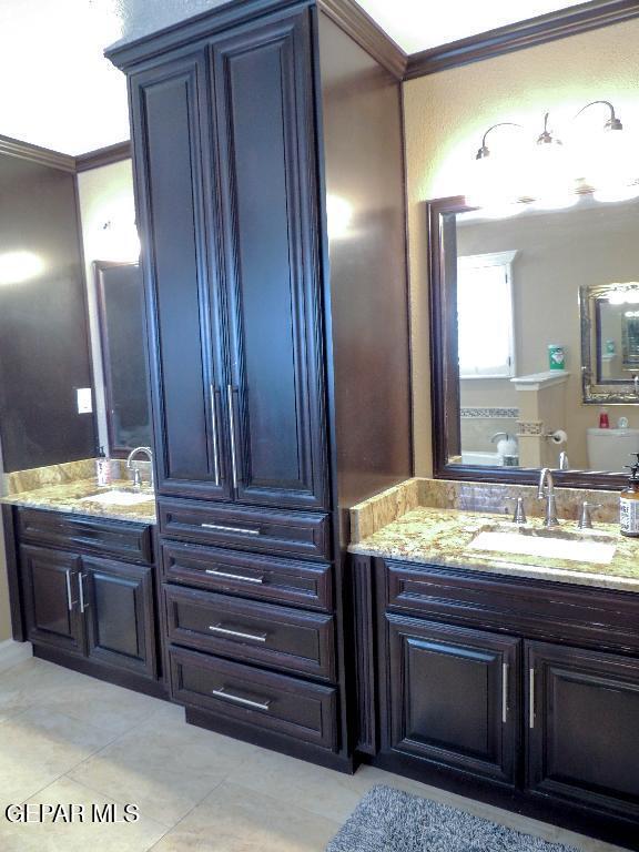 10945 Gary Player Dr, El Paso, TX 79935 - bathroom featuring crown molding, tile patterned floors, and vanity