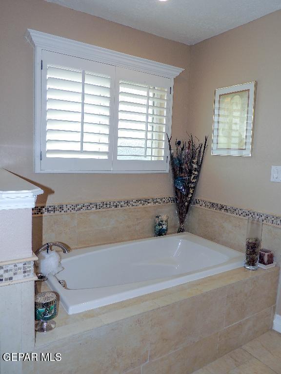 10945 Gary Player Dr, El Paso, TX 79935 - bathroom with a bath and tile patterned floors