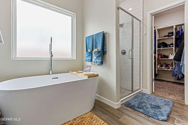 14753 Charles Foster Ave, El Paso, TX 79938 - full bath with a walk in closet, a freestanding tub, a stall shower, and wood finished floors