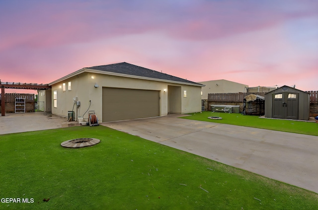 14753 Charles Foster Ave, El Paso, TX 79938 - view of front of house with an outdoor fire pit, concrete driveway, a storage shed, a garage, and stucco siding