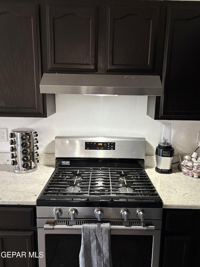 632 Manzanilla Pl, El Paso, TX 79928 - kitchen view of stainless steel range with gas stovetop, under cabinet range hood, and dark brown cabinets