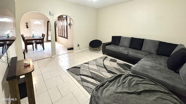 632 Manzanilla Pl, El Paso, TX 79928 - living area featuring arched walkways, light tile patterned floors, and a textured ceiling