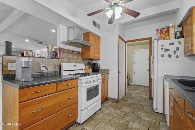 10106 Mercedes St, El Paso, TX 79924 - kitchen featuring white appliances, wall chimney range hood, backsplash, ceiling fan, and brown cabinetry