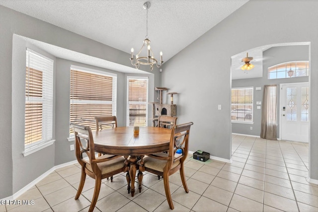 11651 Great Spirit Cir, El Paso, TX 79936 - dining area with light tile patterned floors, a chandelier, a textured ceiling, vaulted ceiling, and a ceiling fan