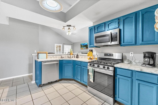 11651 Great Spirit Cir, El Paso, TX 79936 - kitchen featuring appliances with stainless steel finishes, blue cabinetry, a peninsula, light countertops, and vaulted ceiling