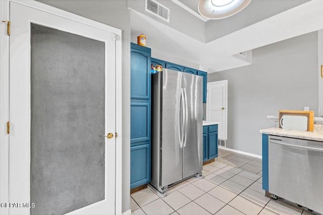 11651 Great Spirit Cir, El Paso, TX 79936 - kitchen with blue cabinetry, appliances with stainless steel finishes, light countertops, and light tile patterned floors