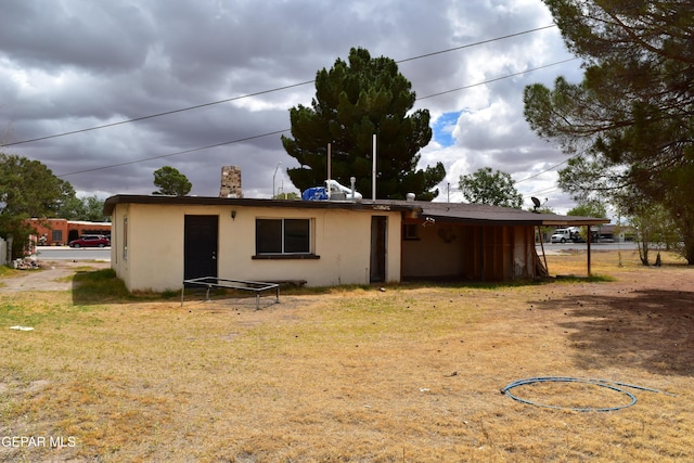 7556 N Loop Dr, El Paso, TX 79915 - rear view of house featuring stucco siding and a lawn
