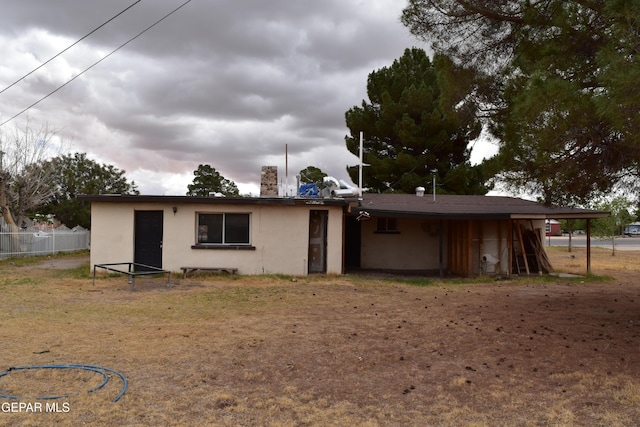 7556 N Loop Dr, El Paso, TX 79915 - rear view of property featuring stucco siding and an attached carport