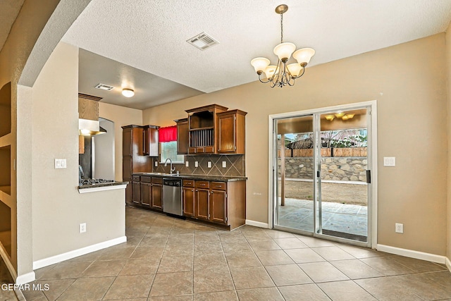 12308 Sombra Grande Dr, El Paso, TX 79938 - kitchen with appliances with stainless steel finishes, dark countertops, a chandelier, backsplash, and light tile patterned floors