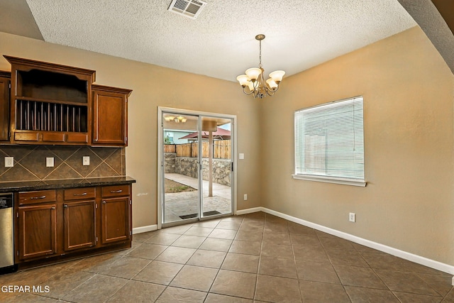 12308 Sombra Grande Dr, El Paso, TX 79938 - kitchen with a chandelier, dark tile patterned flooring, decorative backsplash, open shelves, and a textured ceiling