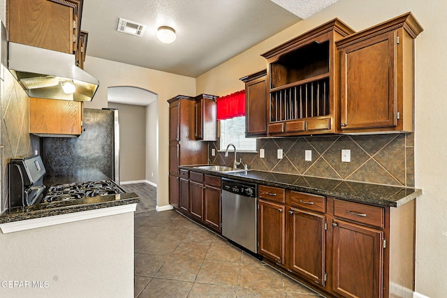 12308 Sombra Grande Dr, El Paso, TX 79938 - kitchen with stainless steel appliances, arched walkways, tasteful backsplash, tile patterned flooring, and under cabinet range hood
