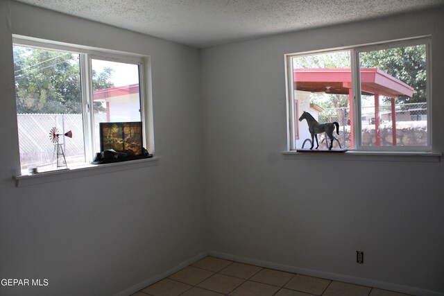 5124 Edmonton Ave, El Paso, TX 79924 - unfurnished room with healthy amount of natural light, a textured ceiling, and light tile patterned flooring