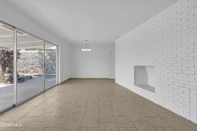 6033 Isabella Dr, El Paso, TX 79912 - spare room featuring brick wall, a textured ceiling, and a chandelier