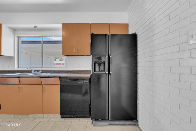 6033 Isabella Dr, El Paso, TX 79912 - kitchen featuring black appliances, dark countertops, light tile patterned floors, and brick wall