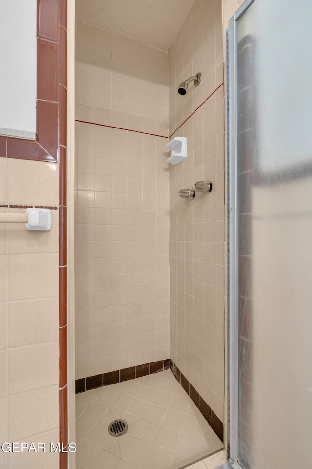6033 Isabella Dr, El Paso, TX 79912 - full bathroom featuring a stall shower, tile patterned floors, and tile walls