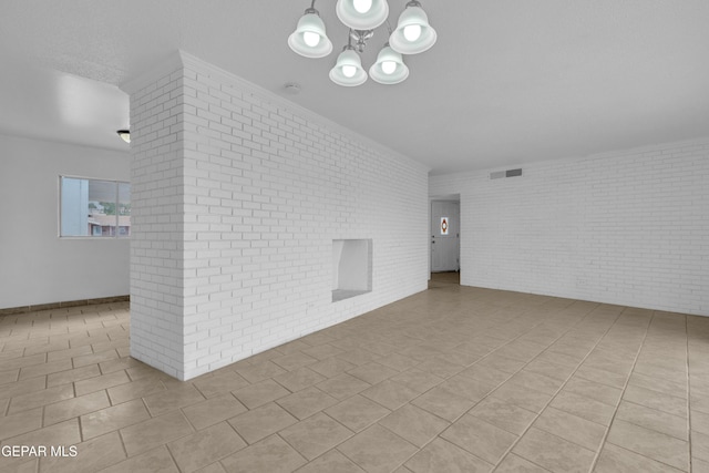 6033 Isabella Dr, El Paso, TX 79912 - tiled spare room with brick wall and a chandelier