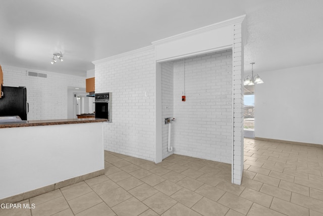 6033 Isabella Dr, El Paso, TX 79912 - unfurnished living room featuring light tile patterned floors, a chandelier, a fireplace, and a wood stove