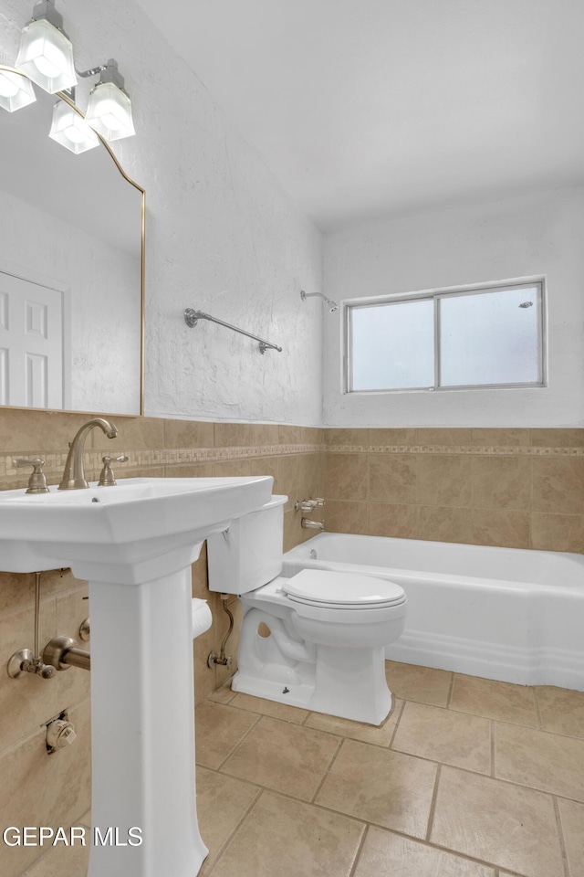 6033 Isabella Dr, El Paso, TX 79912 - full bathroom featuring tile walls, tile patterned flooring, and tub / shower combination
