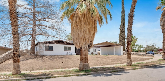 6033 Isabella Dr, El Paso, TX 79912 - view of front facade featuring stucco siding, driveway, and a carport