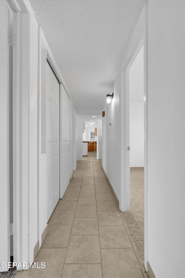 6033 Isabella Dr, El Paso, TX 79912 - corridor featuring a textured ceiling and light tile patterned flooring