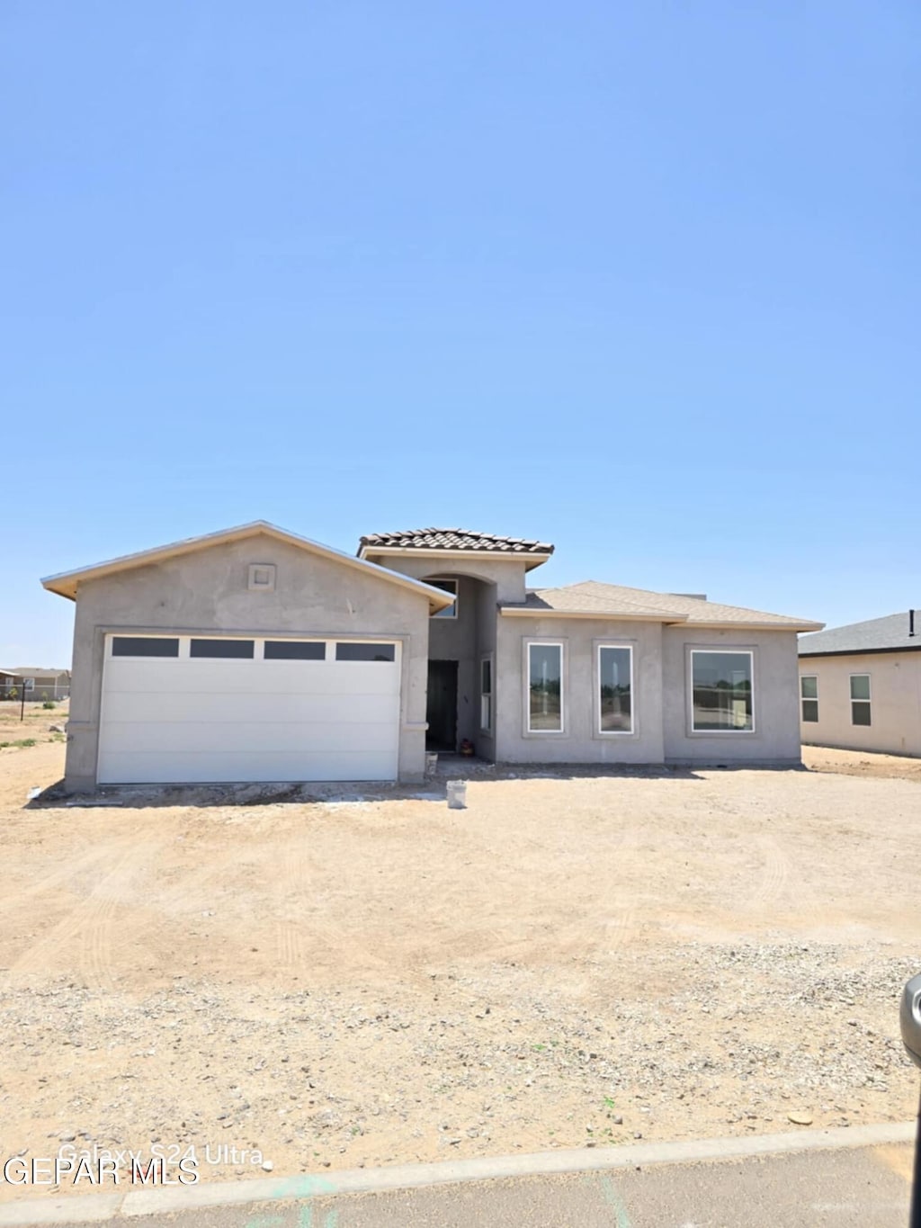 450 Perla Bonita Rd, Clint, TX 79836 - view of front of house with stucco siding, driveway, an attached garage, and a tile roof