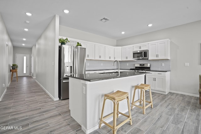 2308 Enchanted Quail, El Paso, TX 79911 - kitchen featuring stainless steel appliances, light wood-style floors, white cabinets, backsplash, and recessed lighting