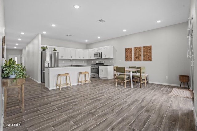 2308 Enchanted Quail, El Paso, TX 79911 - kitchen with appliances with stainless steel finishes, dark wood-style flooring, recessed lighting, white cabinetry, and backsplash
