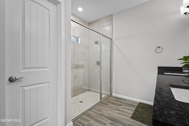 2308 Enchanted Quail, El Paso, TX 79911 - bathroom featuring a stall shower, wood finished floors, double vanity, and recessed lighting
