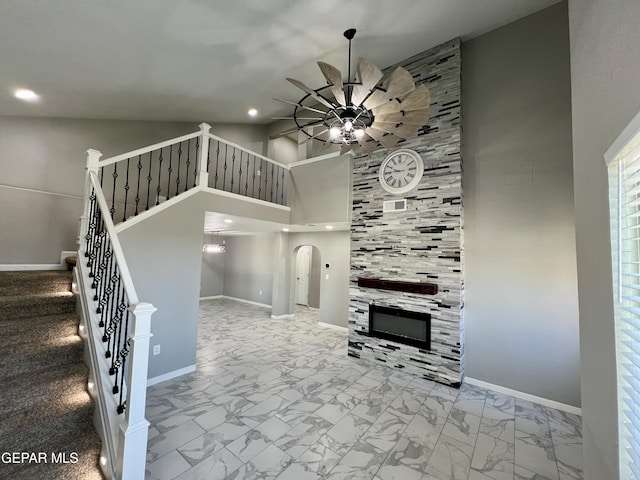1160 Cielo Mar Dr, Socorro, TX 79927 - unfurnished living room with a ceiling fan, marble look tiles, a towering ceiling, recessed lighting, and a fireplace